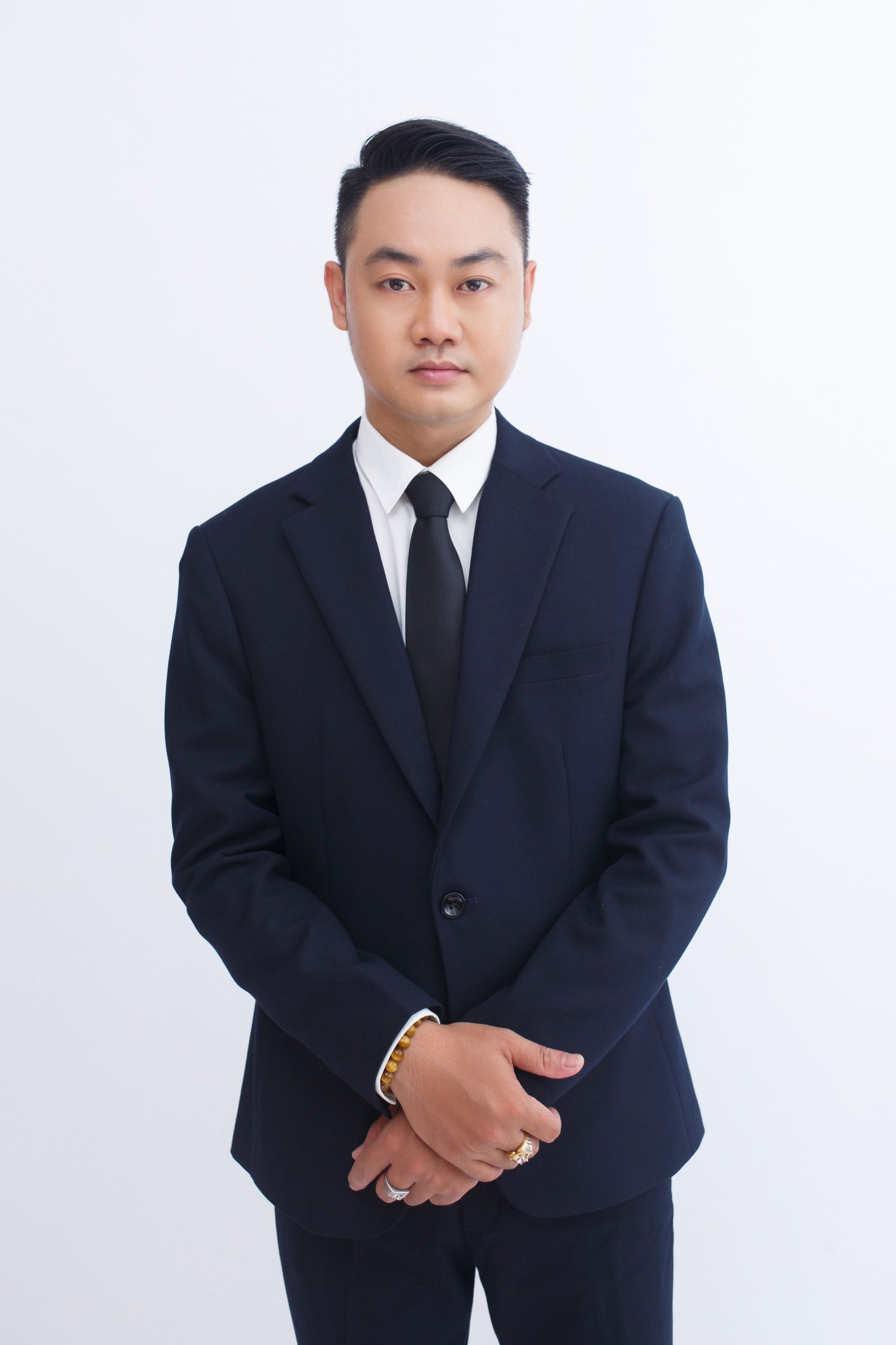 Elegant portrait of an adult businessman in a dark suit, posing with a confident expression.